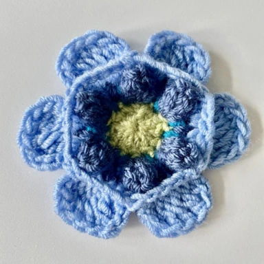 Round 5. Crochet granny square flower - pale blue petals with page green centre