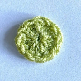small green crochet circle. Round 1.