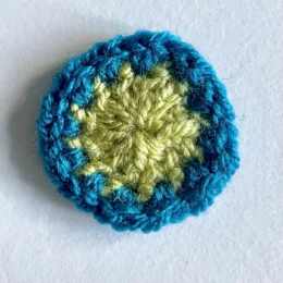 Round 2. Small green crochet circle with blue border