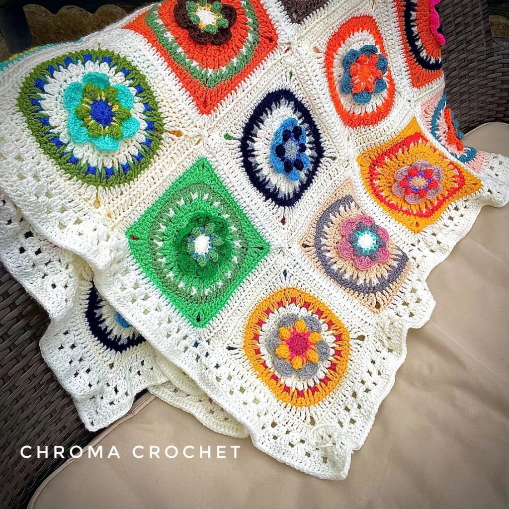 Brightly multi-coloured crochet granny square blanket wrapped over a sofa
