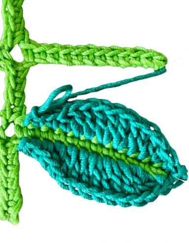 Close up of a crochet leaf vein with the leaf crocheted in a darker green showing the stitches used for the crochet leaves stem free pattern.